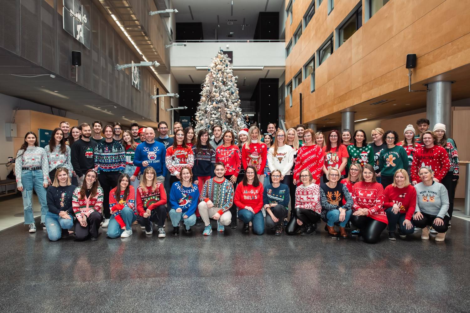 Skupinska fotografija zaposlenih in študentov na FERI v božičnih puloverjih. Bolj resna.