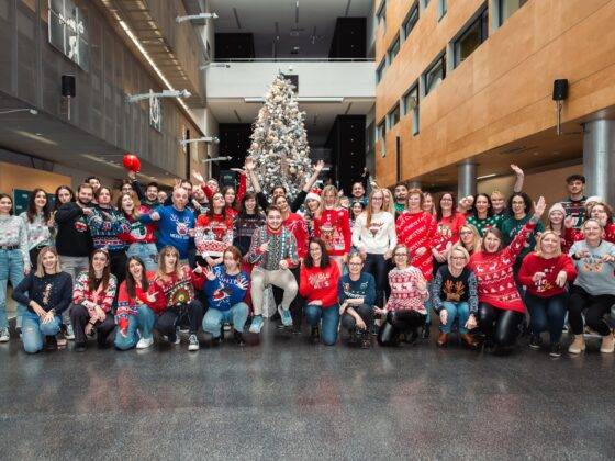 Skupinska fotografija zaposlenih in študentov na FERI v božičnih puloverjih. Bolj zabavna.